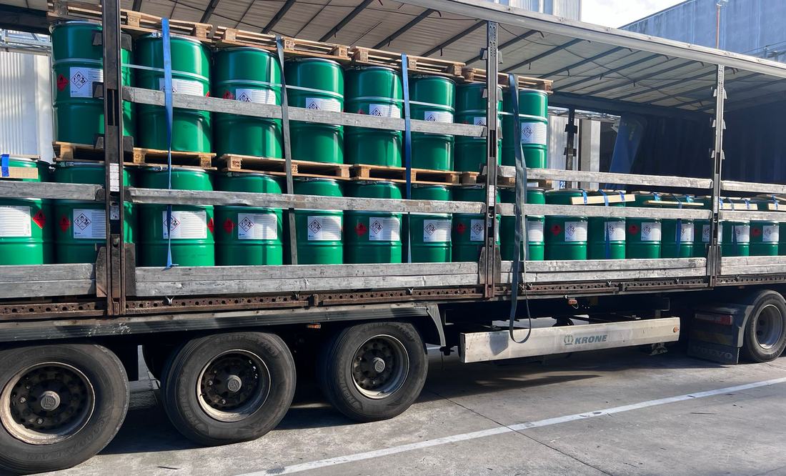 Labelled drums of regulated product strapped on a Delphic trailer